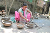 an women is making bowl with clay